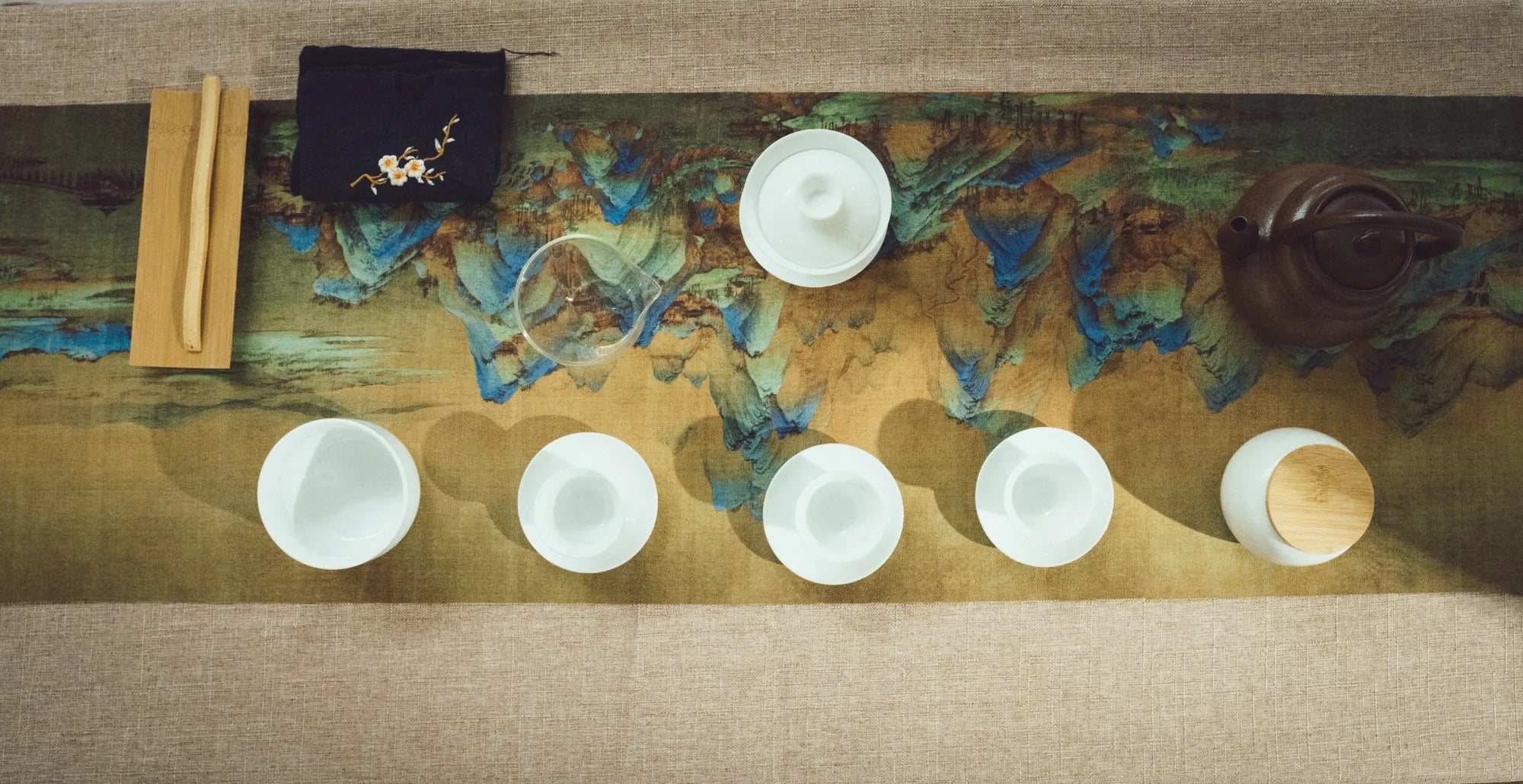 Chinese tea ceremony table with Yixing teapot, gaiwan, tea cups, and premium tea ware for traditional Gongfu tea preparation.